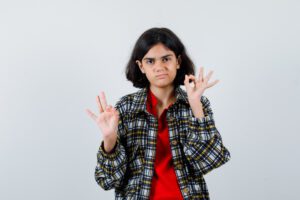 little girl showing ok gesture shirt jacket looking pleased front view